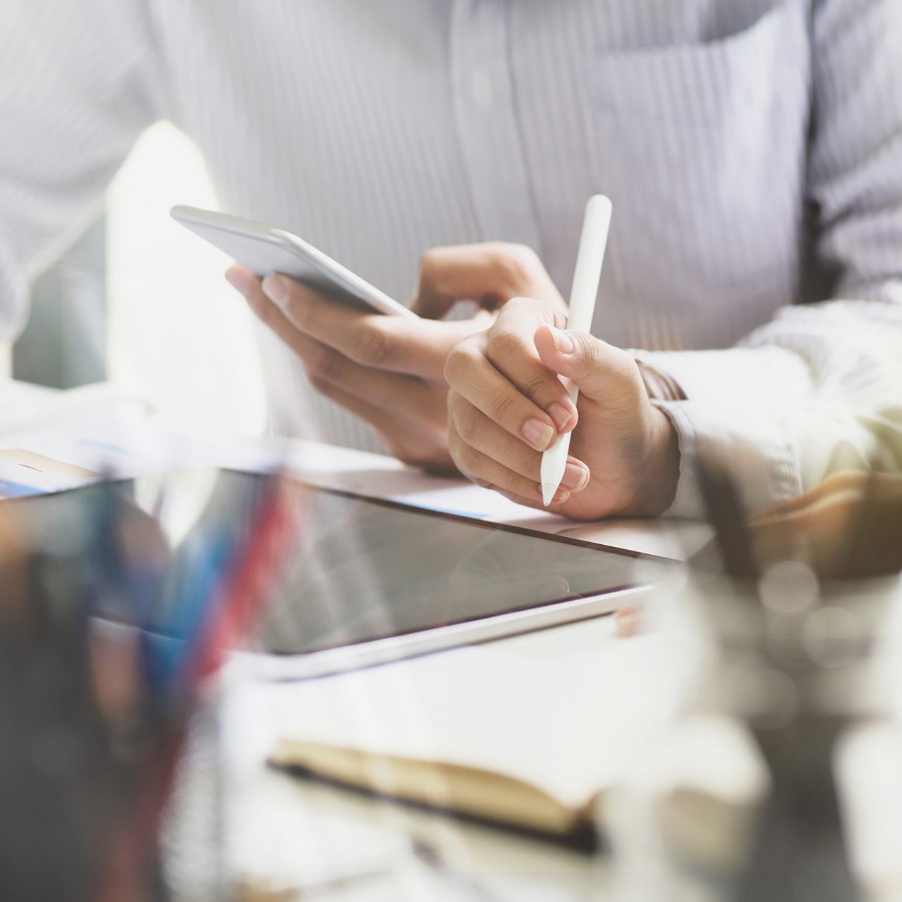 Business couple using tablet and mobile phone in modern office